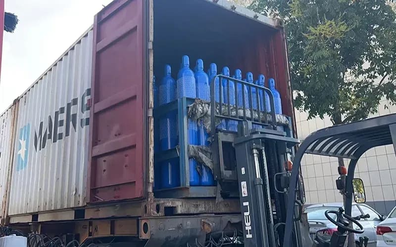 Video showing gas cylinders being loaded into a container with a forklift。